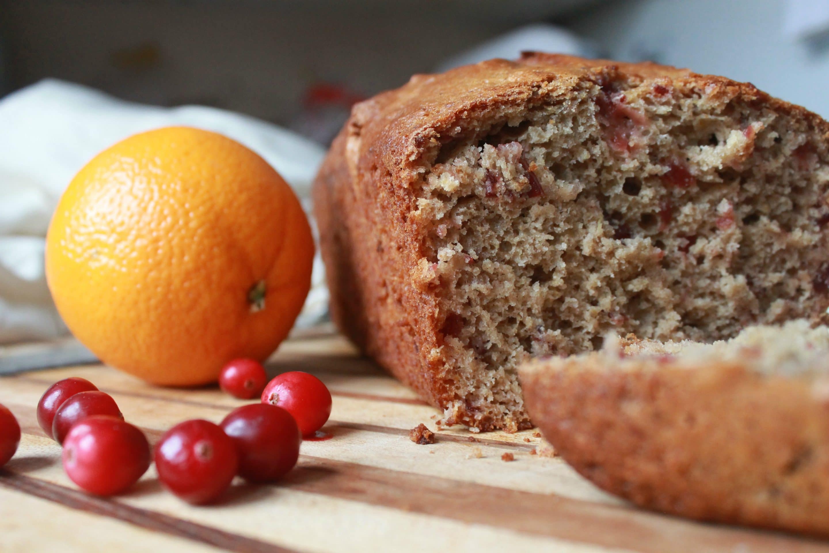 Cranberry Orange Bread with cranberries and an orange